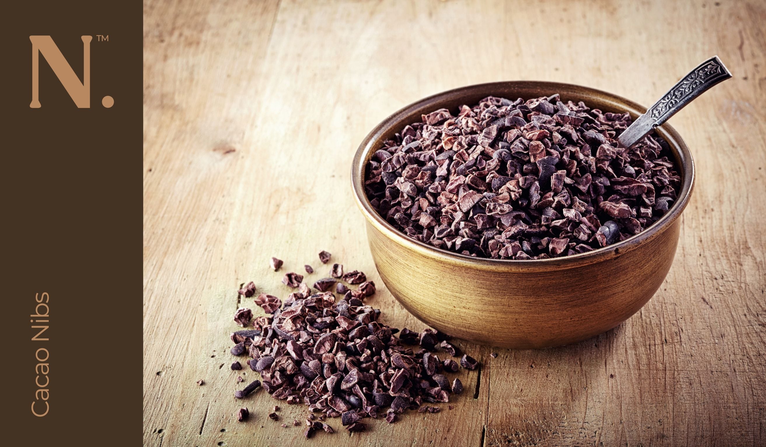 cacao nibs in a wooden bowl with a spoon