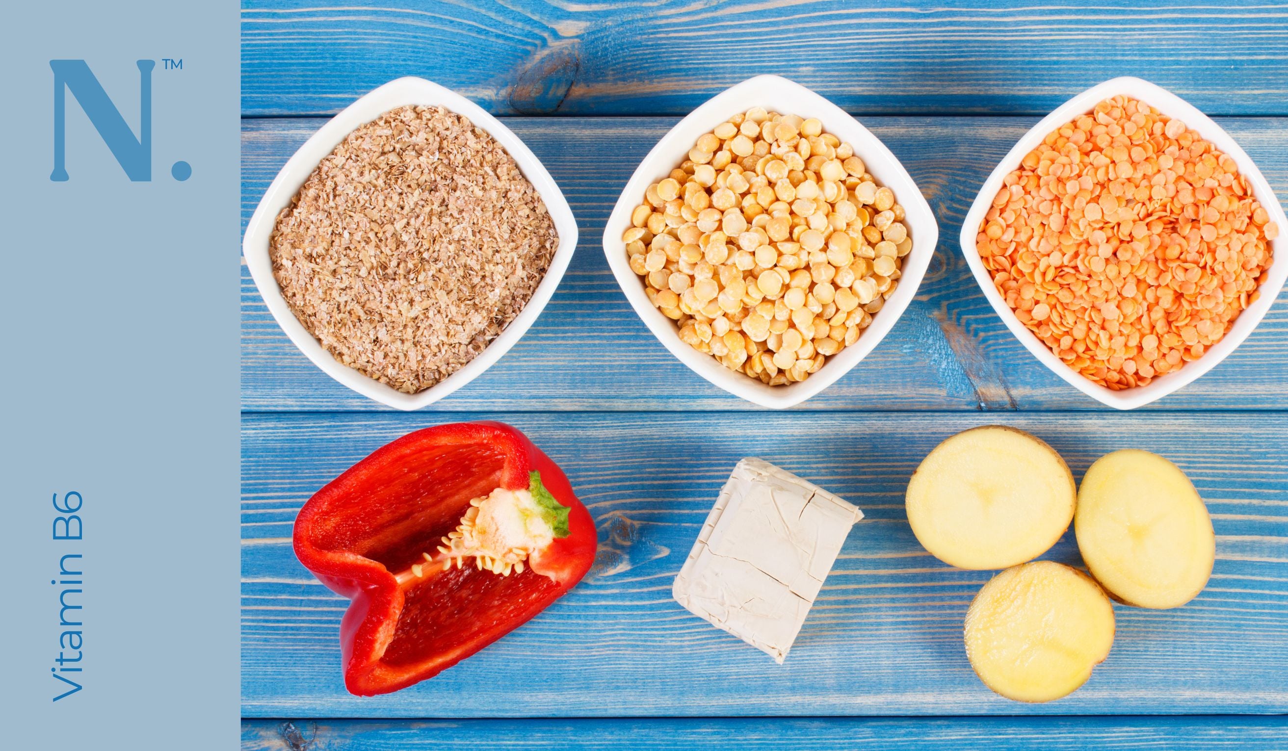 seeds, red pepper and potatoes representing vitamin b6 on top of blue planks of wood