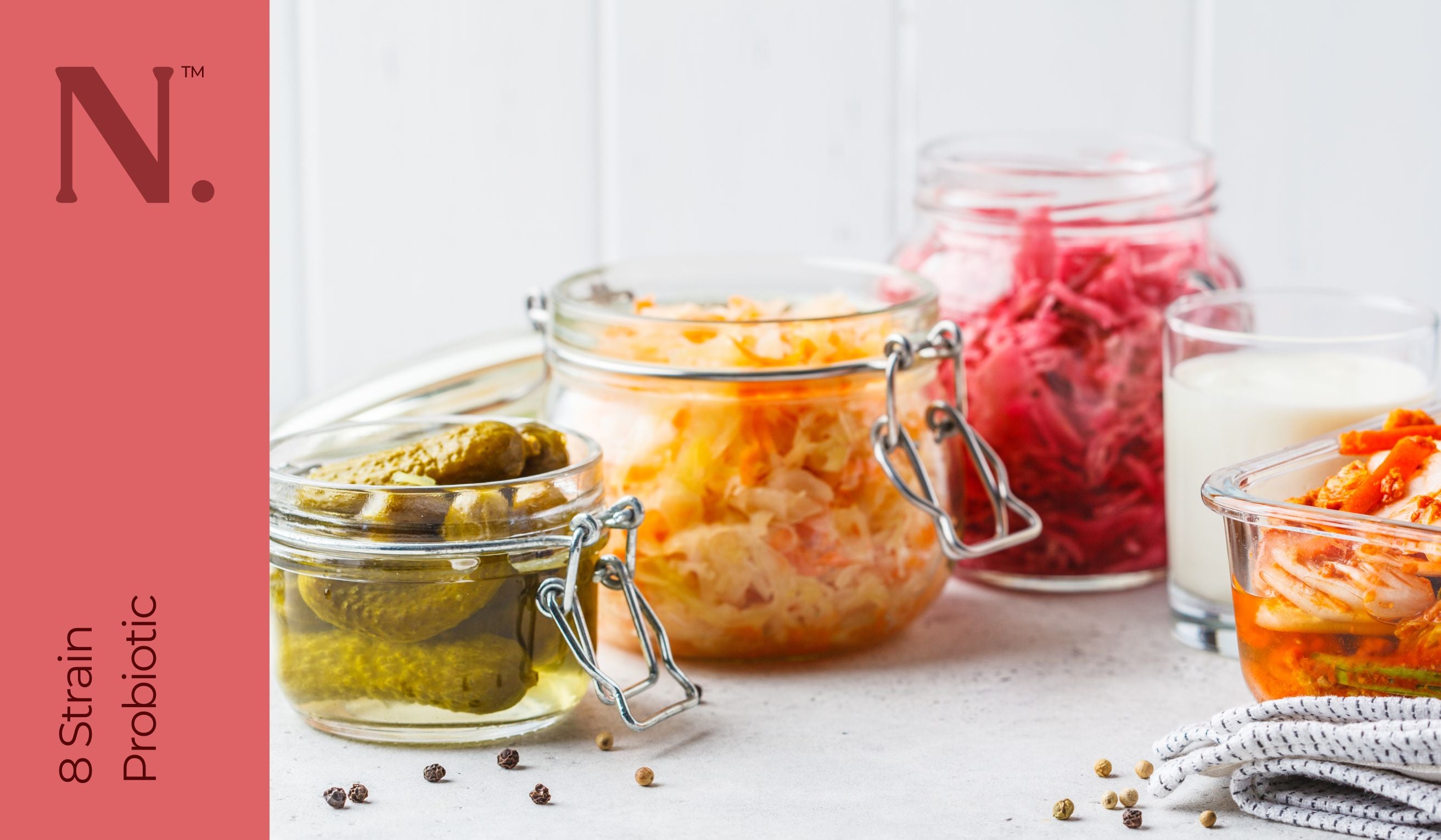 Various glass jars with gherkins, red cabbage ina and glass of milk - 8 Strain Probiotic